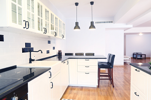 Kitchen with black counter tops and white cupboards