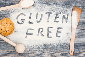 A picture of a board with flour and wooden spoons saying gluten free