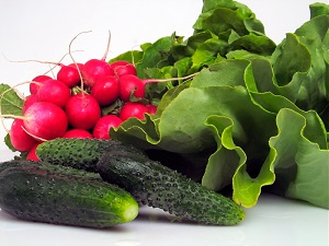 Fresh vegetables including radishes, cucumbers, and lettuce greens