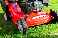 Red lawn mower on grass