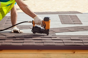 Roofer putting on shingles